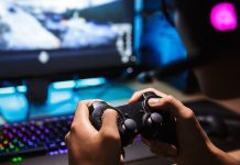 Μαζικές απολύσεις για την Activision Blizzard Ένα αγόρι που κρατάει χειριστήριο και παίζει video game