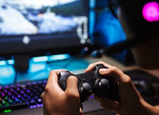Μαζικές απολύσεις για την Activision Blizzard Ένα αγόρι που κρατάει χειριστήριο και παίζει video game